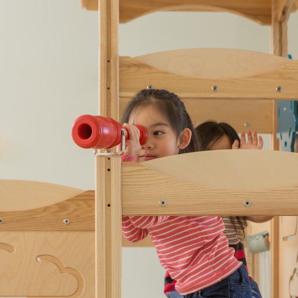 Girl playing with a spyglass in a commercial playset
